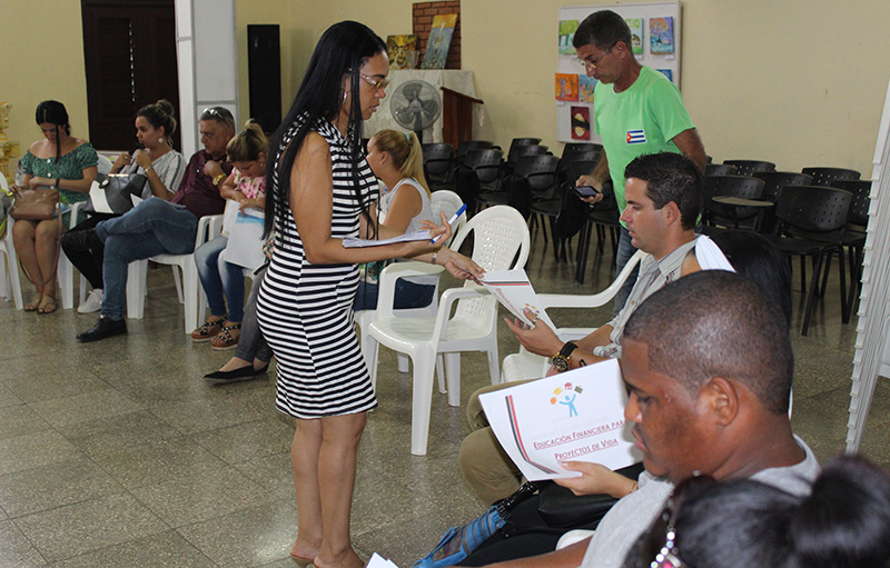 Daysi Espinosa Chongo, una de las facilitadoras del Taller, reparte un folleto que complementará lo aprendido