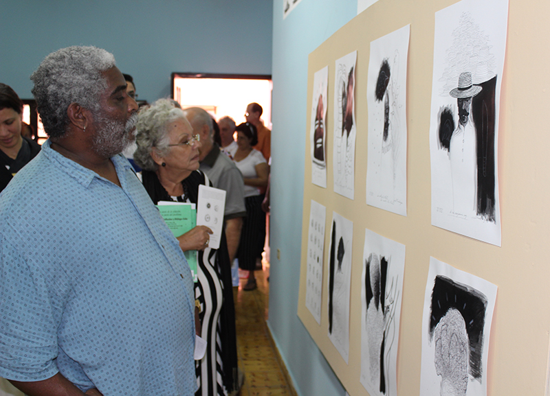 Victor-Fowler-Director-del-Centro-Cultural-Dulce-María-Loynaz-y-Nidia-Mora-madre-del-intelectual-cubano-Rufo-Caballero-aprecian-la-obra-de-Sancho