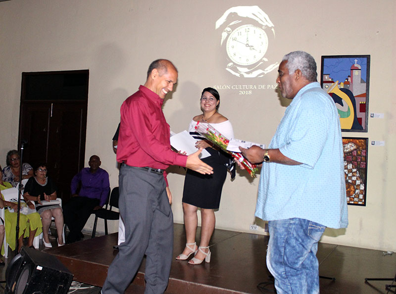 El intelectual cubano Víctor Fowler Calzada (a la derecha) entrega el 3er Premio del salón al cortometraje Alba