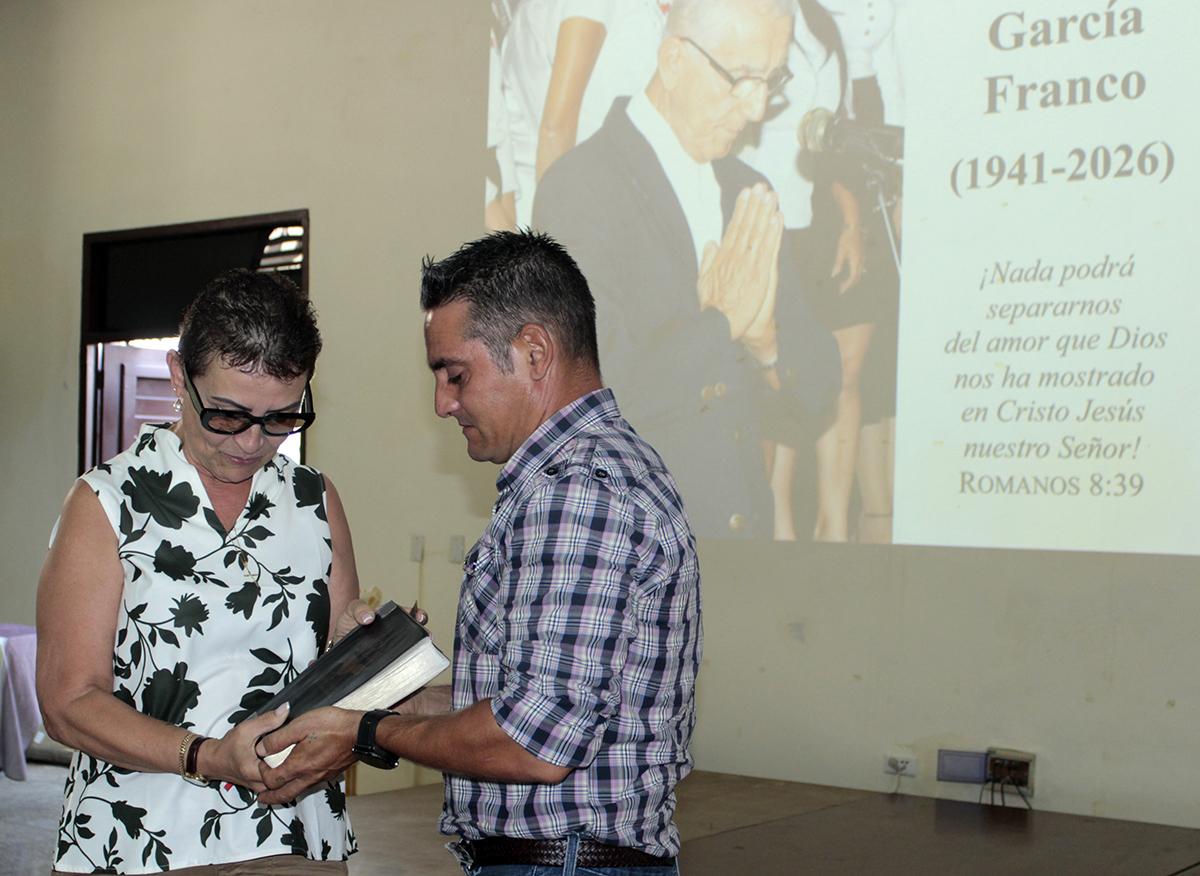 Rita María García Morris entrega la Bilblia que perteneció a su padre a su cuidador Raiko Palmet Bermúdez