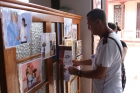 Roberto A. González, director de Trilogía para el ahora de Cuba, coloca algunas fotos y el programa antes de la puesta en escena en el municipio Los Palos