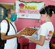 La empleada de esta dulcería entrega dulces varios, destinados a los niños, a Alfredo Rojas, especialista del CCRD-C