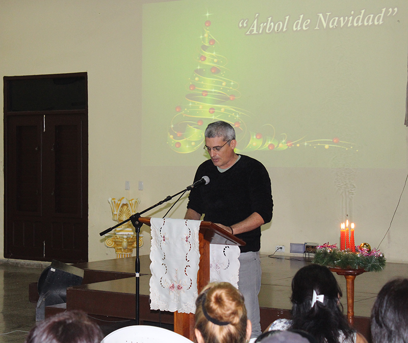 Frank A. Velázquez, especialista de la Pastoral para la Reflexión y el Diálogo da lectura a poema Árbol de Navidad