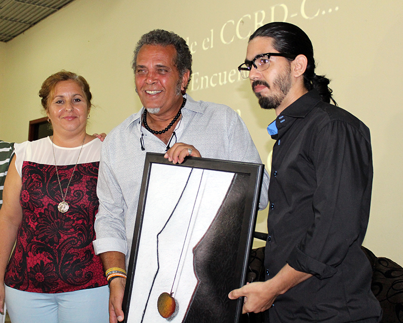 El artista cardenense Adrián Gómez Sancho le entrega a Luis Alberto García su cuadro 1er lugar en el Salón Artístico Cultura de Paz