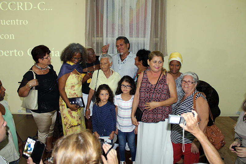 Las personas asistentes a la actividad se toman fotografías junto a Luis A. García y sus hijas