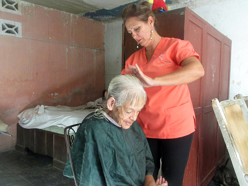 Asistente realizando el servicio de pelado a un beneficiario
