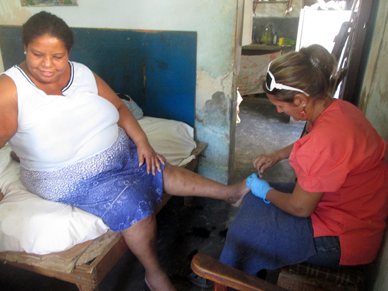 Asistente realizando el servicio de podología a una beneficiaria