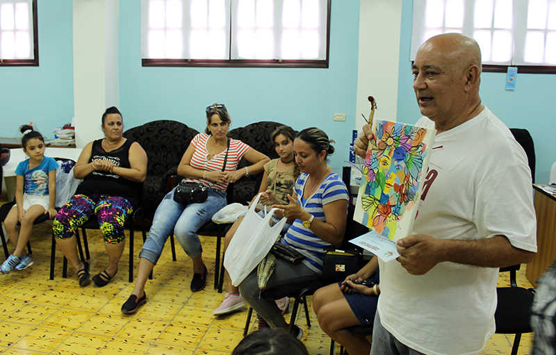 Diego Valdés, coordinador del CID muestra la obra del artista plástico Jorge Sergio Ruffín entregada como obsequio al primer lugar del concurso