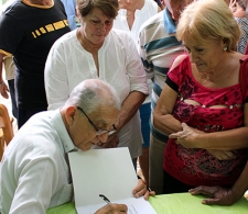 Reverendo Raimundo autografiando su libro
