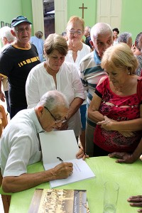 Reverendo Raimundo autografiando su libro