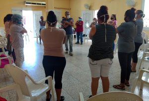 El psicólogo Frank Velázquez (al centro) facilita una dinámica participativa durante el encuentro con padres en Jovellanos